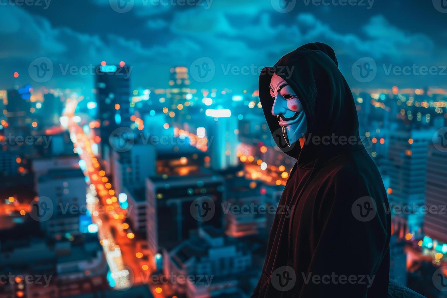 Anonymous hacker in hoodie on cityscape at night photo