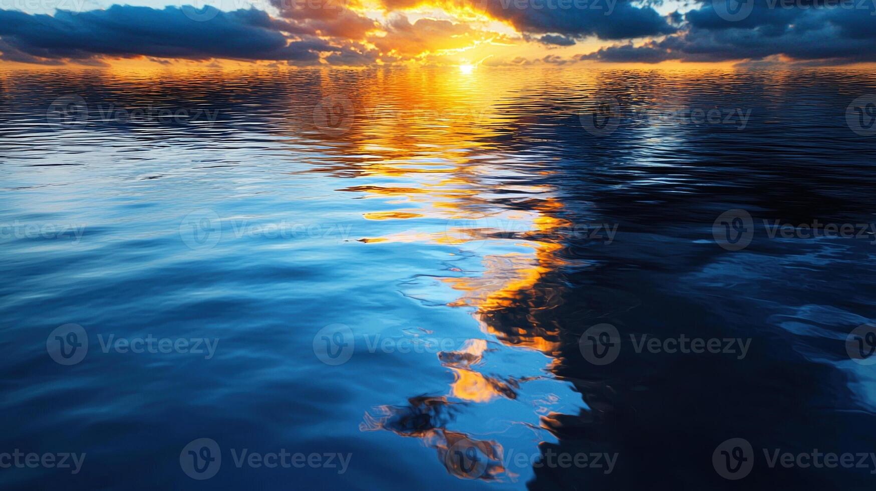 Sunset over the ocean with clouds reflected in the water photo