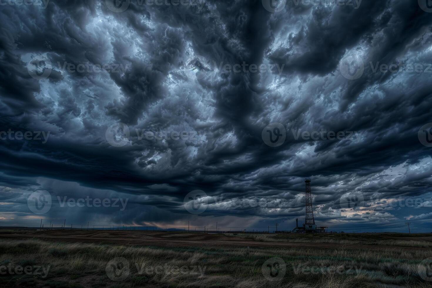 A stormy sky with dark clouds and a tall power line photo