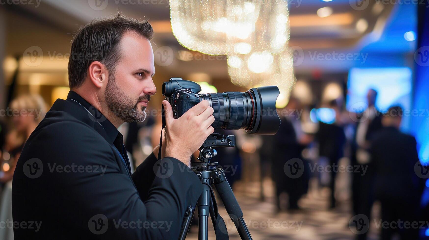 A man is taking a picture of a room with a chandelier photo