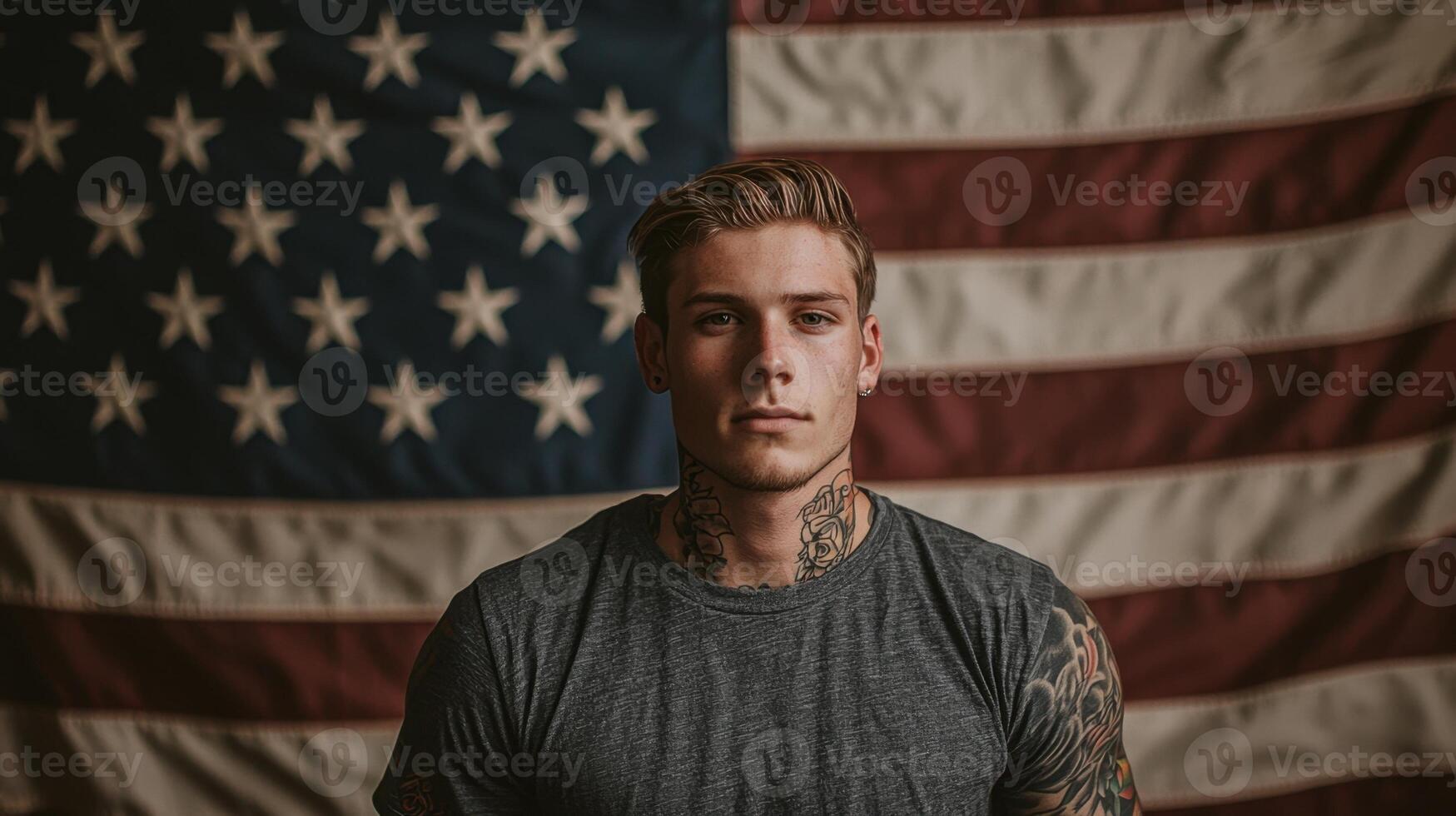 A man with tattoos standing in front of an american flag photo
