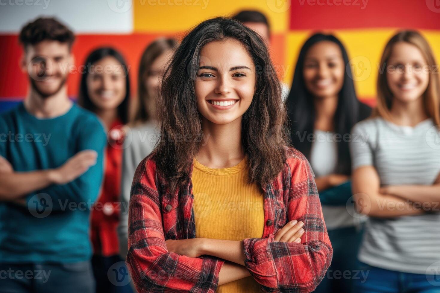 Young woman smiling with folded arms and diverse group of students in background photo