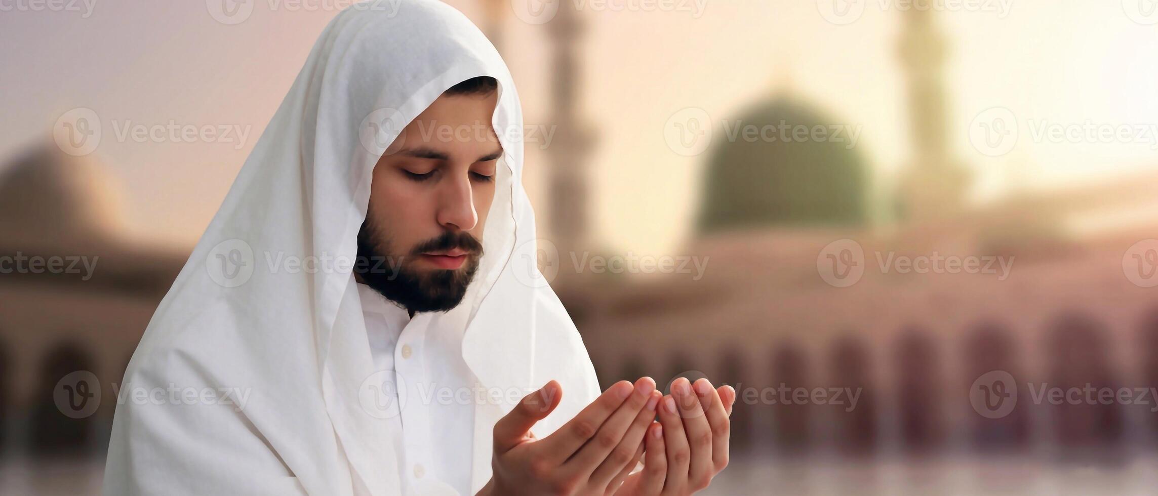 Arabian man in traditional white robe praying with raised hands outside a mosque. Spiritual connection in Islam photo