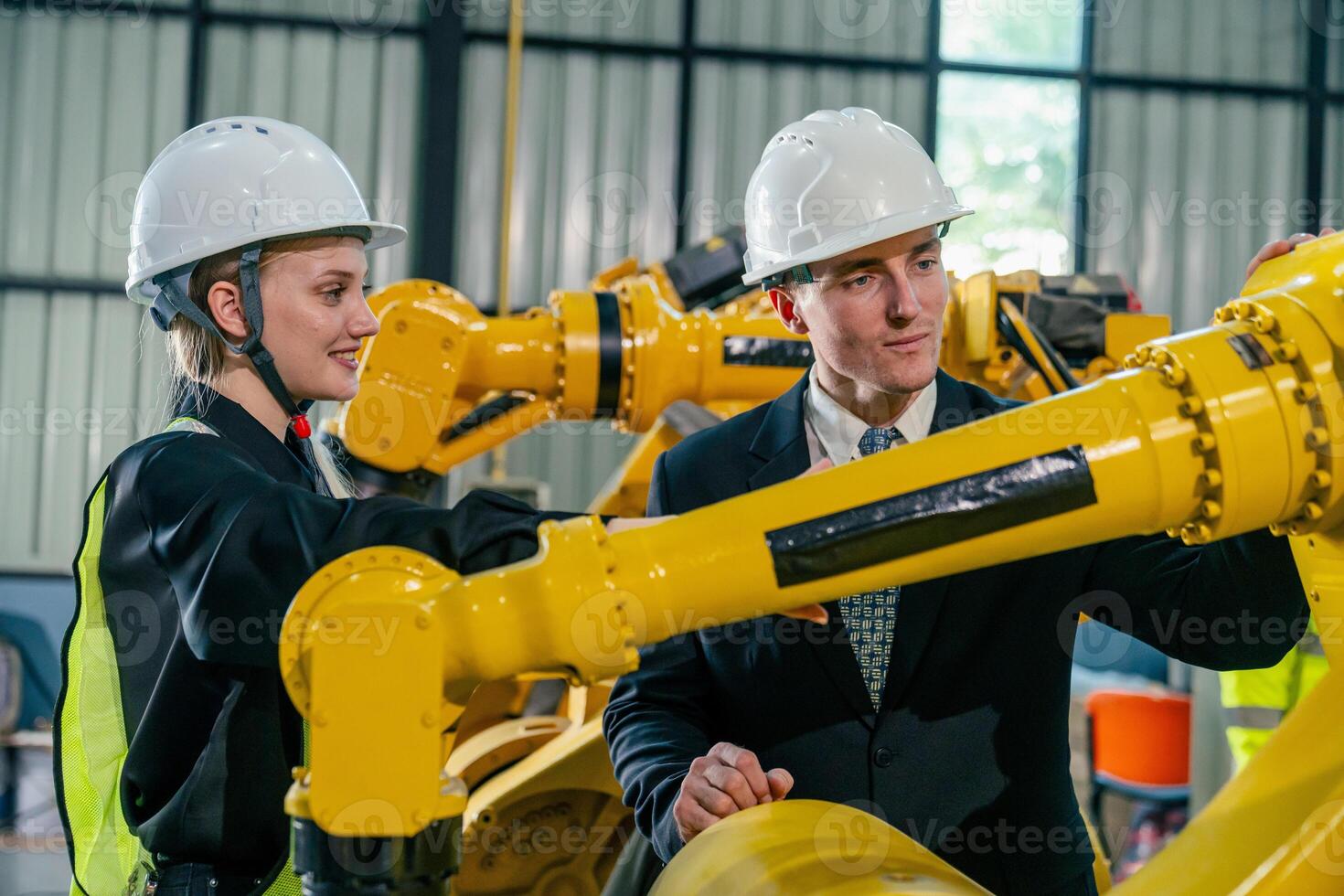 Collaboration between engineers and business professionals in a robotics facility during daylight photo