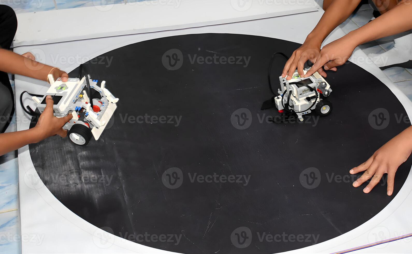 Two robots are on a black surface.1 photo