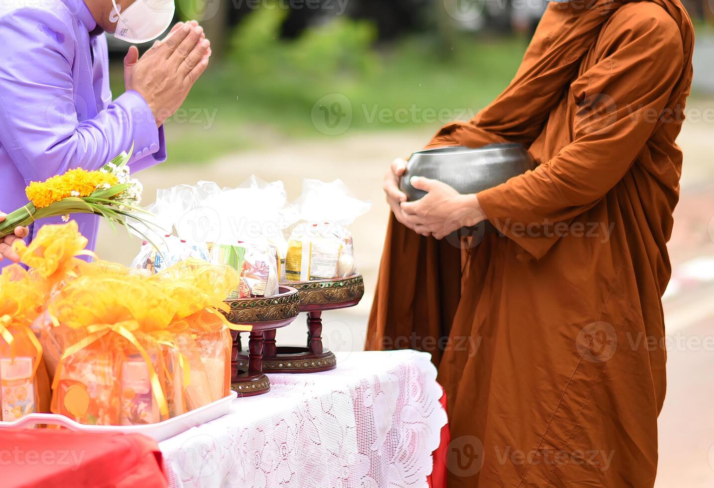 A man in a brown robe is holding a bowl photo