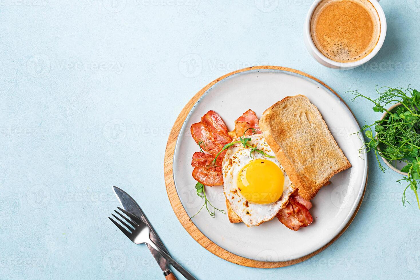 Breakfast toast with fried egg, bacon and microgreens on plate photo