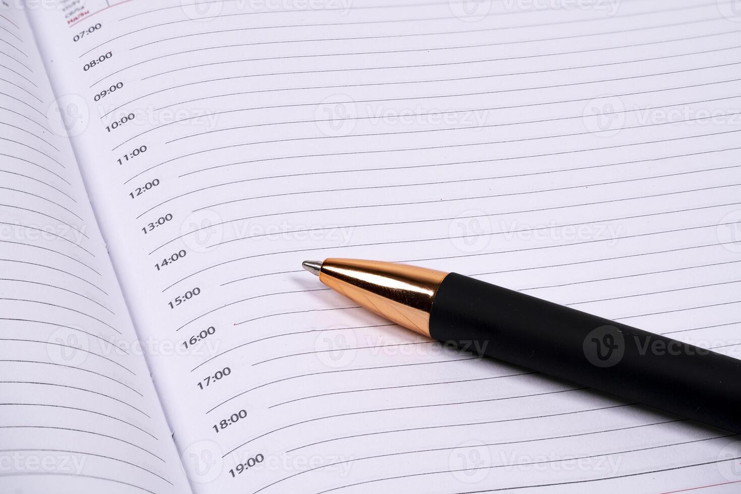 Scheduling tasks with a pen on a blank planner page photo