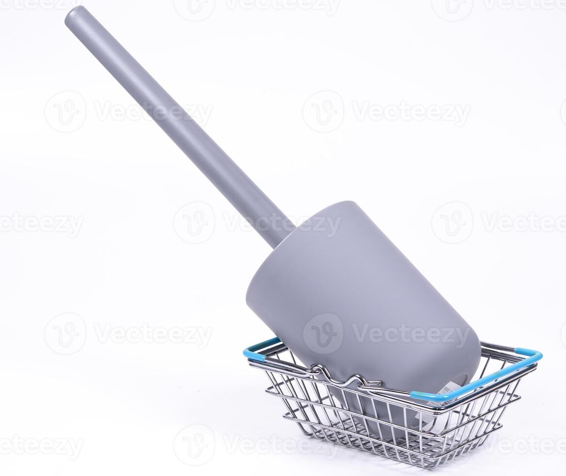 Cleaning tool resting in a shopping basket on a white background photo