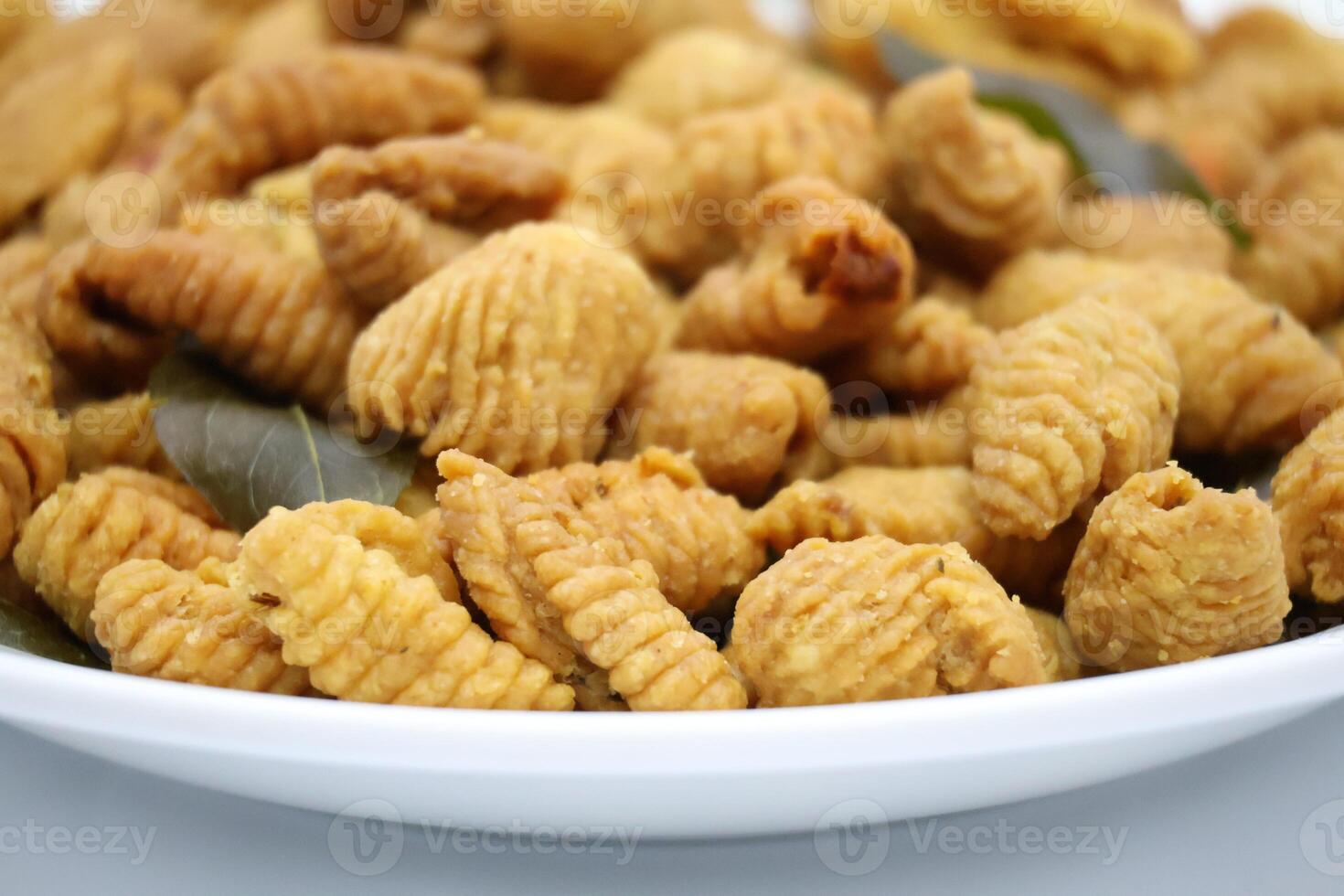 Crafted with care, this Malaysian snack reflects rich culinary tradition. Made of wheat flour, curry powder, and select ingredients, it's fried to crispy perfection, a savory delight loved by many. photo