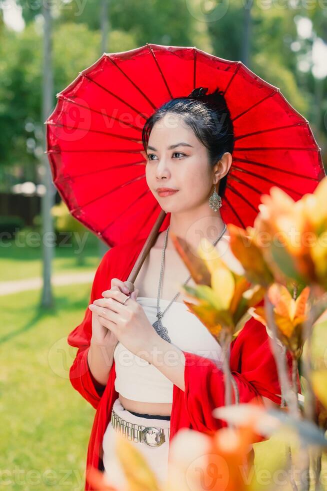 Northern Thai Chiangmai lanna people in traditional style clothes beautiful women old vintage dressing with paper umbrella at wat ton kwen. photo