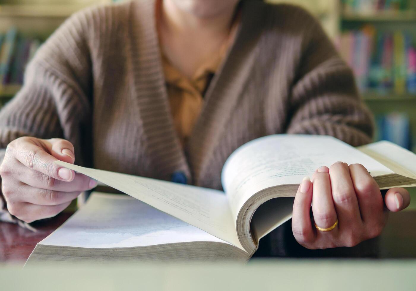 Learning, education Hand of Senior woman sitting reading fiction book on wooden table,relax and enjoy books. photo