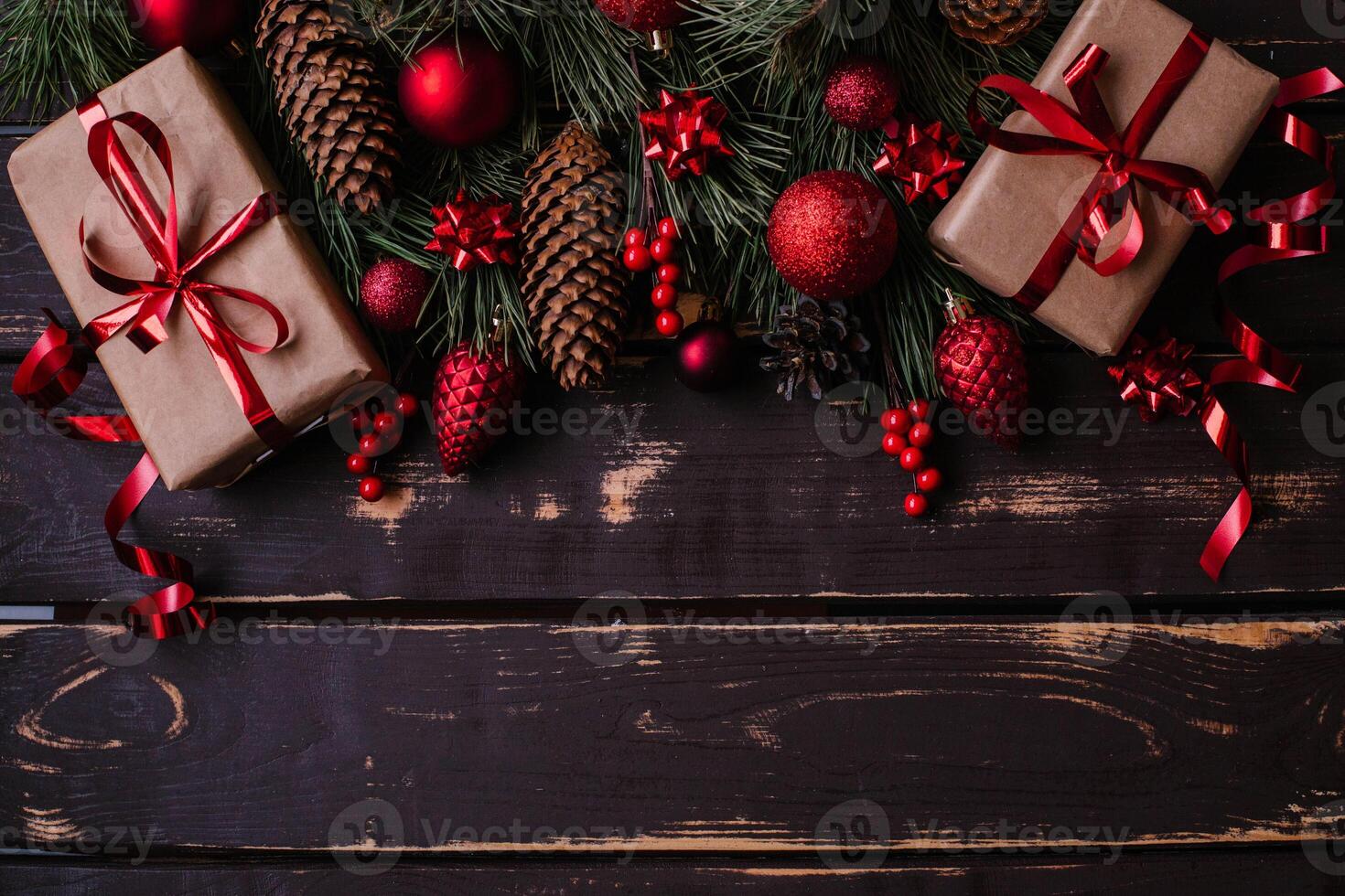 Top view photo Christmass flatlay gift boxes,red christmas tree toys and spruce brance on wooden background. Xmas backdrop with space for text.Copyspace.