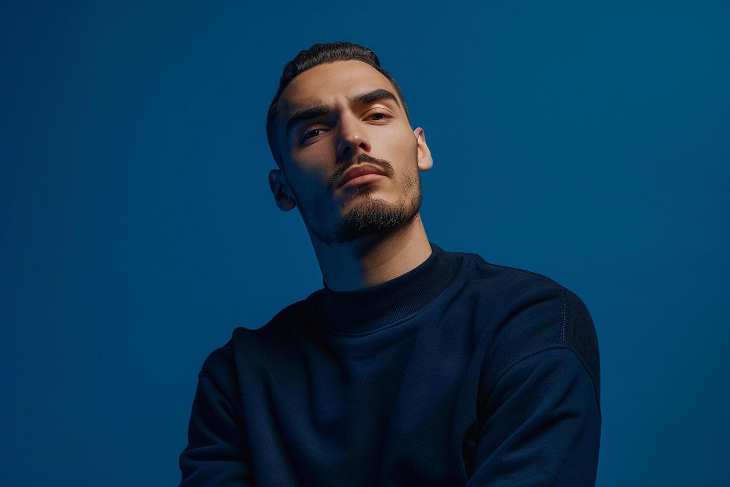 Fashion Male Model in Stylish Sweatshirt with Deep Blue Lifestyle Background Highlighting Contemporary Style photo