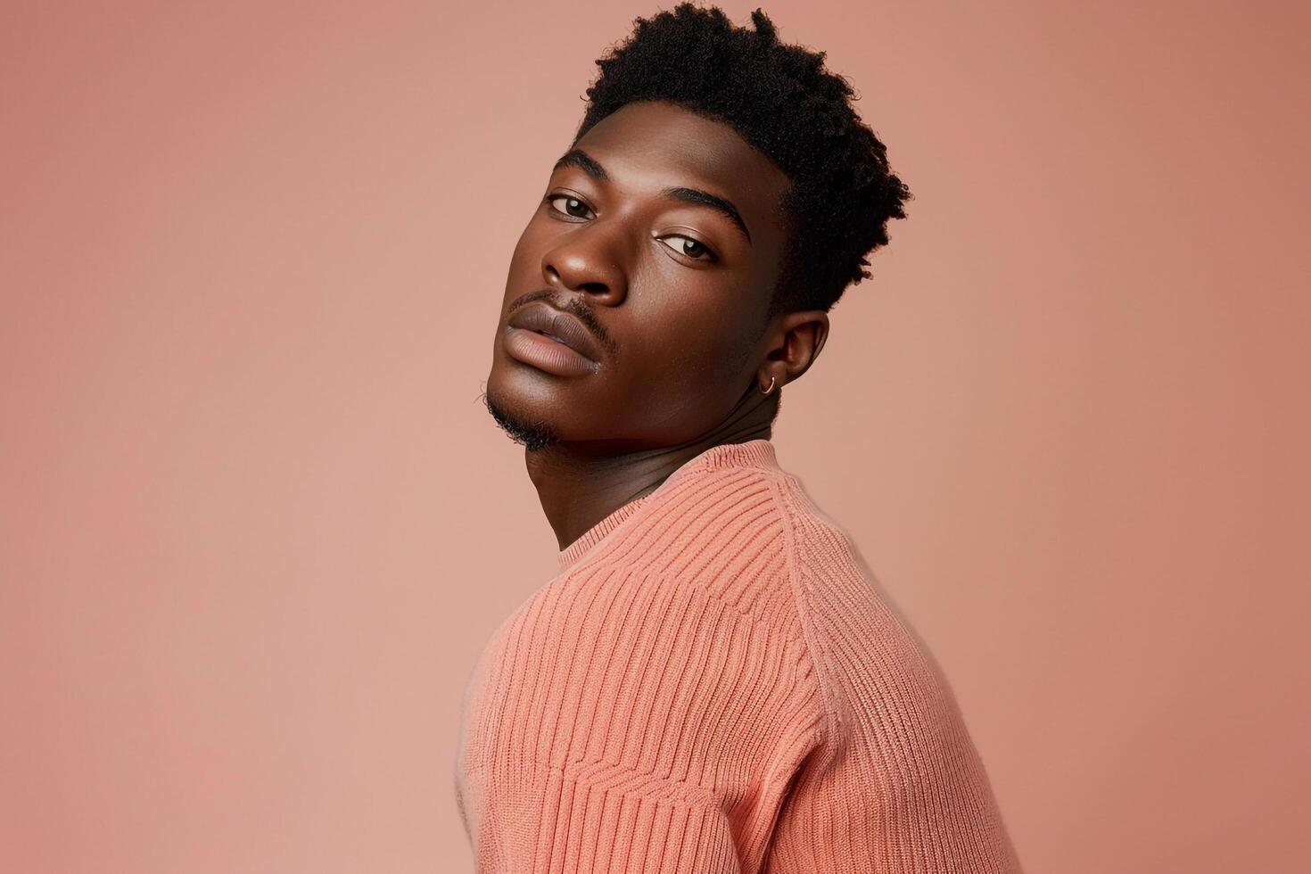 High end Fashion portrait of Male Model in pullover with Light peach Background Showcasing Modern Males Style photo