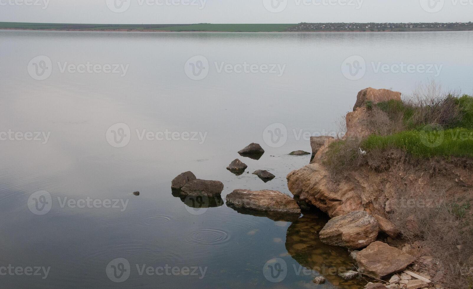 Coast with rocks in the water, Hadzhibey estuary. Reflection in water photo