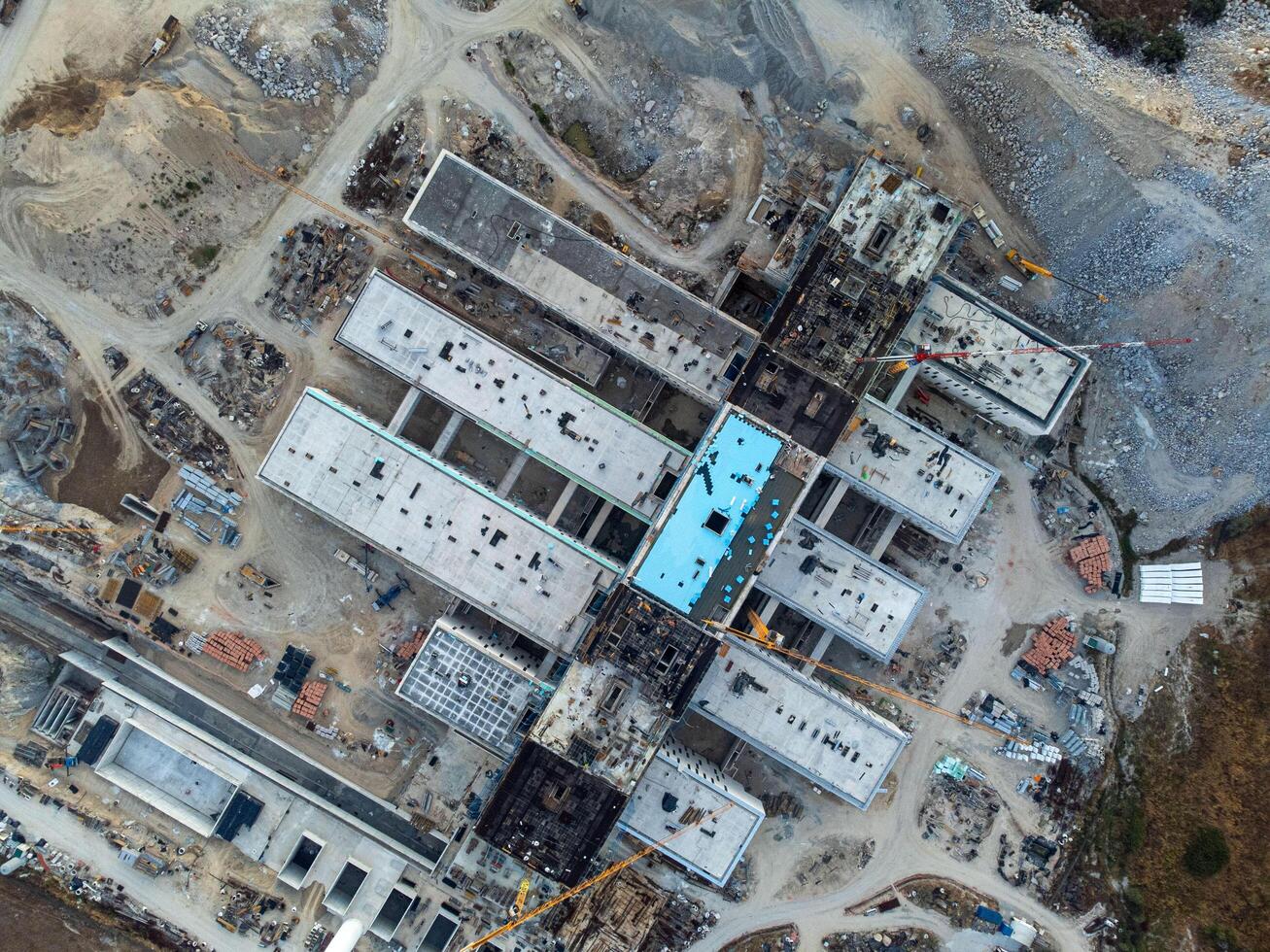 Evora, Portugal. August 8, 2024. Aerial view of the construction site of the new Evora District Hospital, showcasing cranes, scaffolding, and the partially completed modern structure. photo