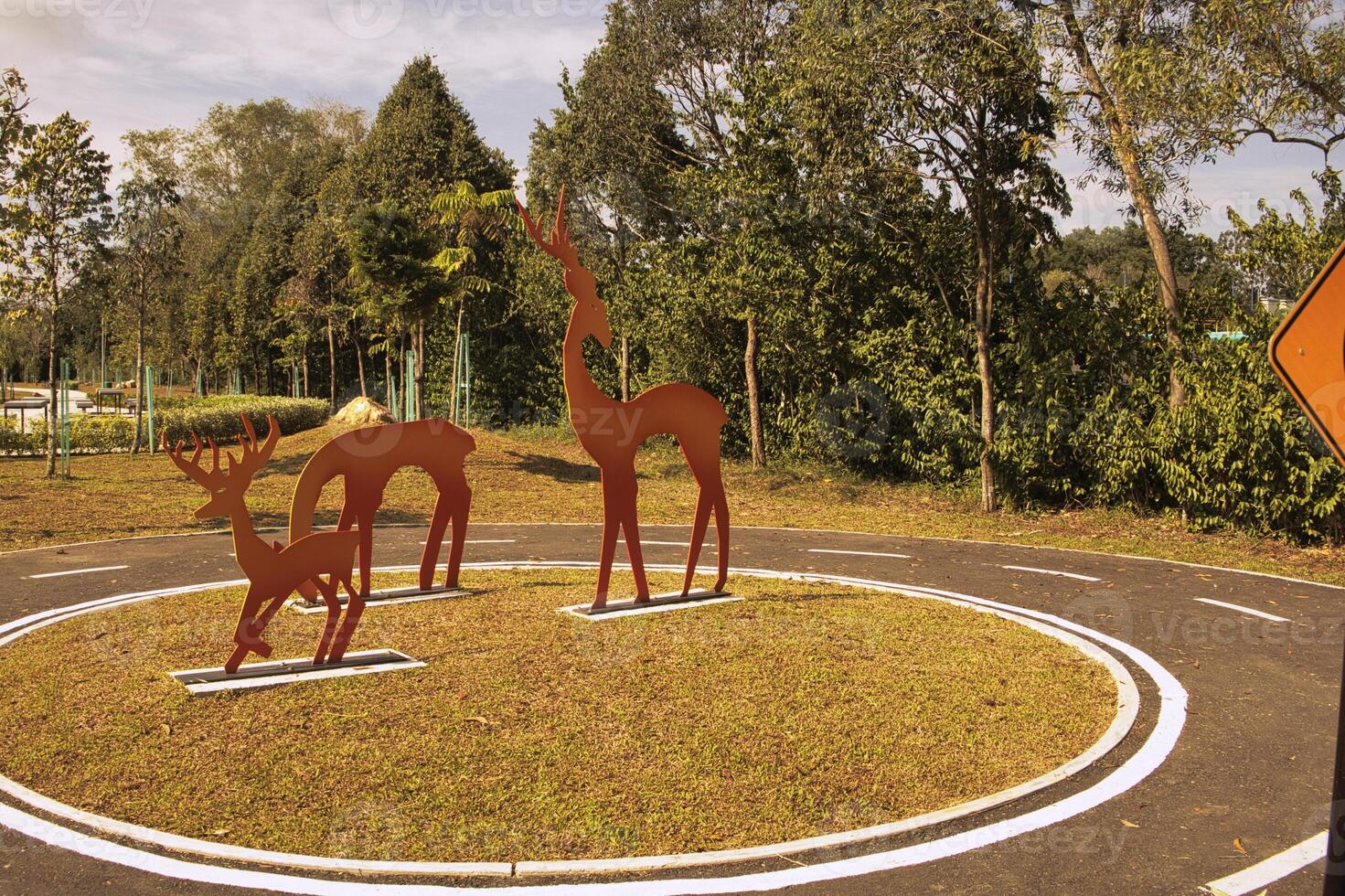 A park with vibrant metal giraffe sculptures painted in gradient colors stands out against the greenery in Taman Tasik Puteri Ijok. photo