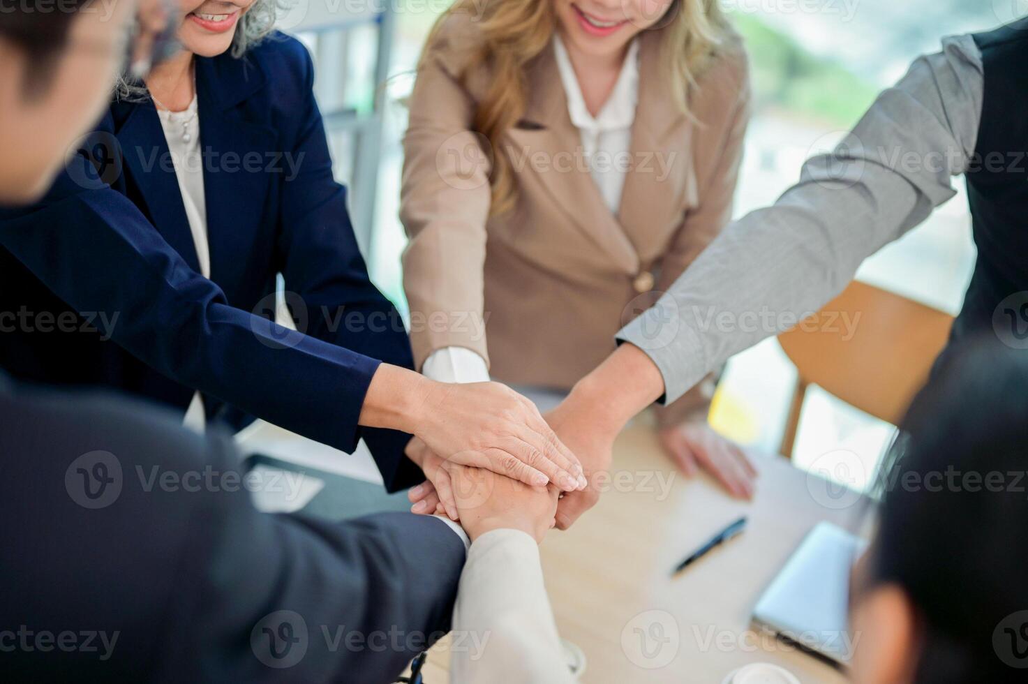 A close-up of businesspeople's hands coming together in a teamwork gesture, celebrating success. photo