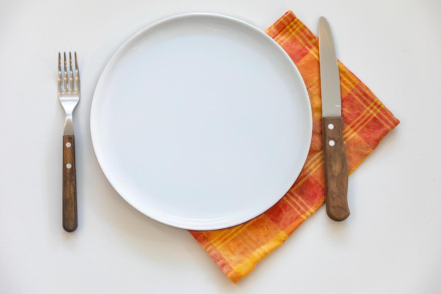 Empty plate top view with metal cutlery next to it photo