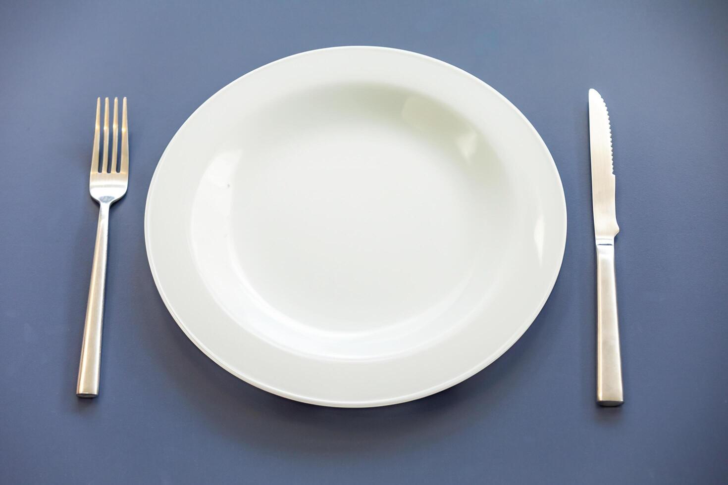 Empty plate top view with metal cutlery next to it photo
