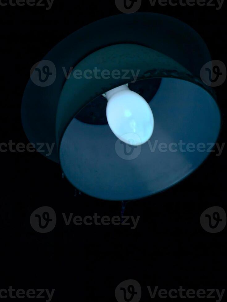 Close up of old mercury-vapor lamp recently started up photo