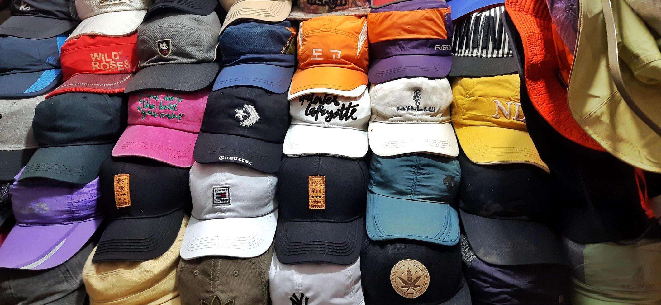 Variety of thrift hats on the display for sale at Pasar Senen. Jakarta, Indonesia - December 11 2024 photo