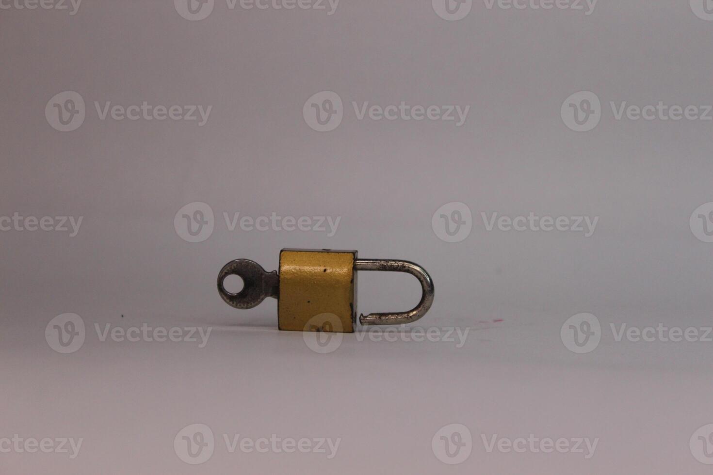 A small padlock on a white surface. photo