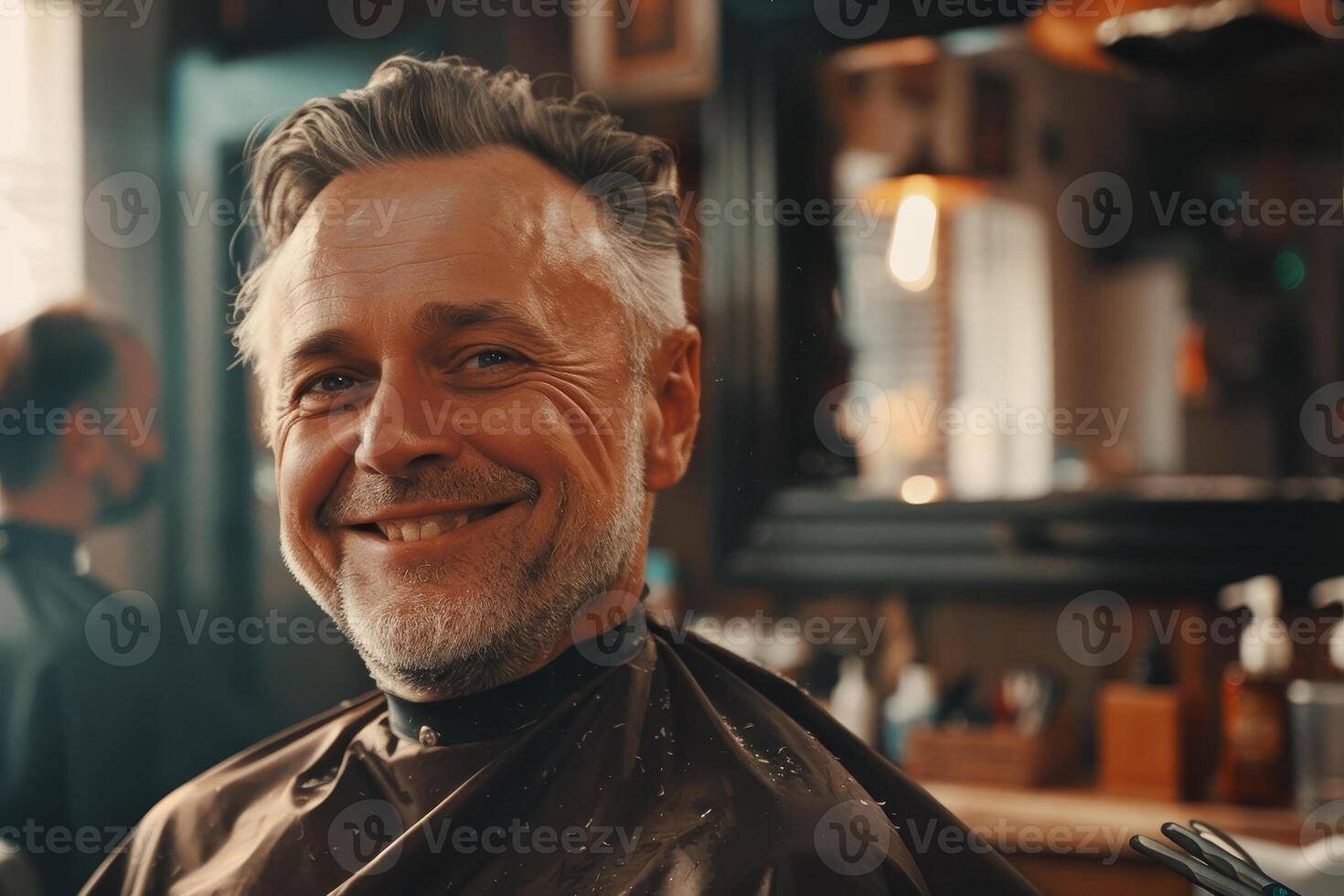 A man is smiling while sitting in a barber chair photo