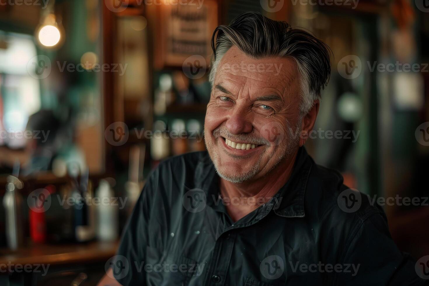 A man smiles while sitting at a bar photo