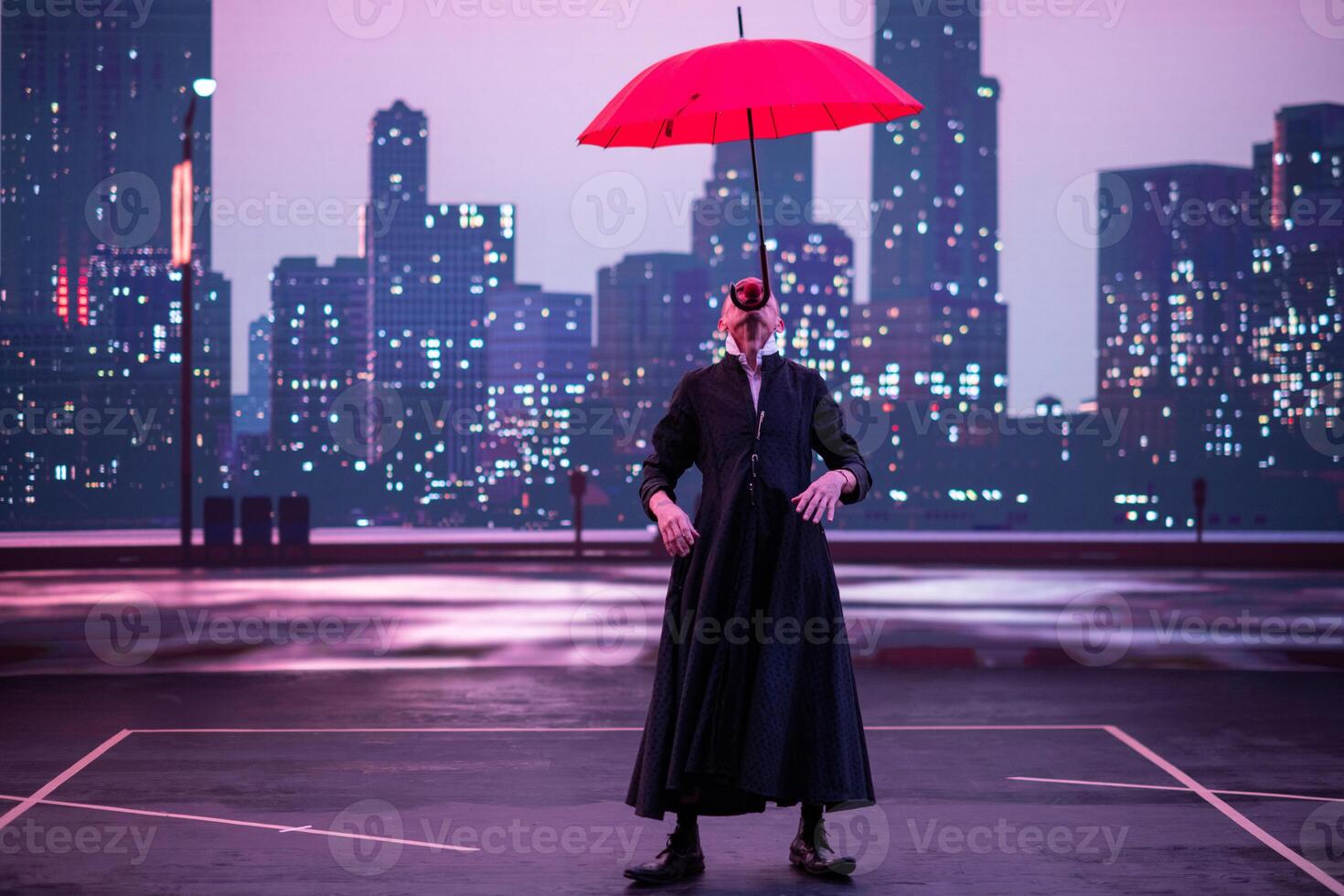 Mysterious Clown Performer with Red Umbrella in Urban Nightscape. photo