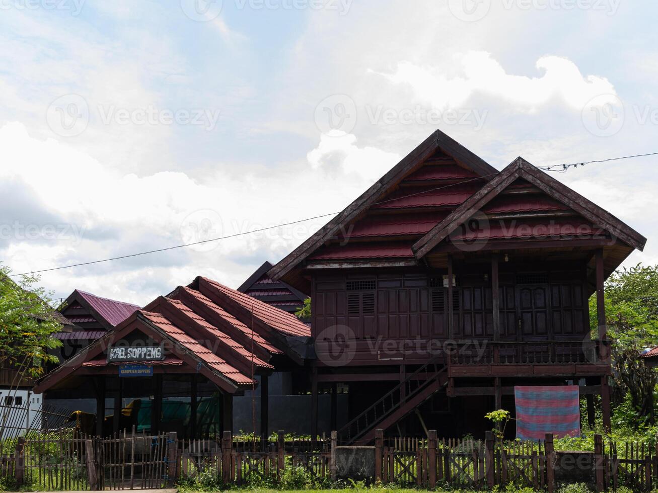 A wide shot of Traditional ethnic house from Soppeng regency South Sulawesi Indonesia with red tile roof in bright sun photo
