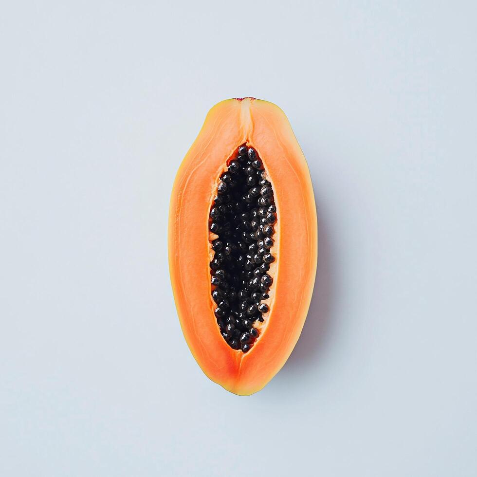 Ripe Halved Papaya Fruit with Black Seeds on Light Blue Background photo