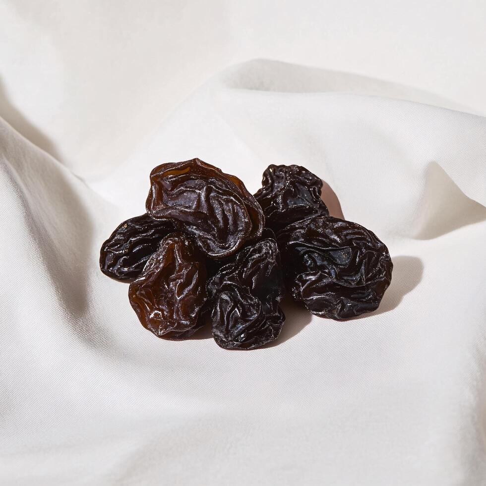 A pile of raisins sitting on a white cloth photo