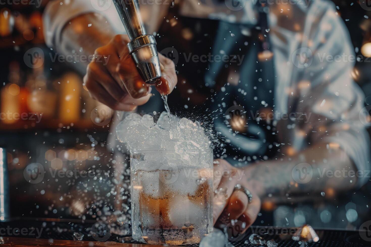 A bartender is pouring a drink into a glass with ice photo