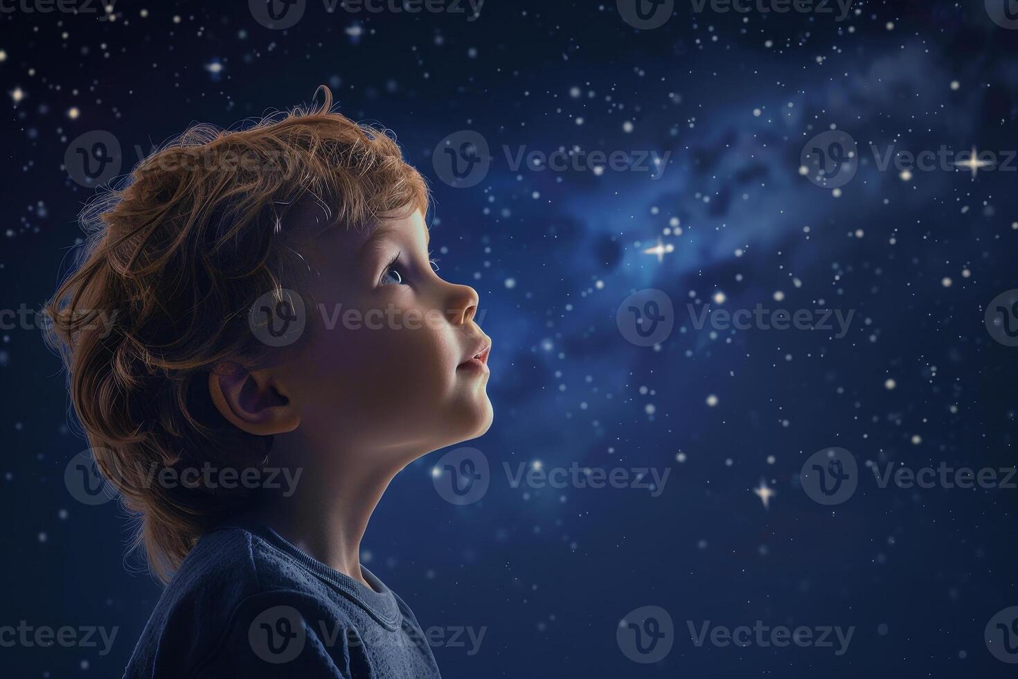 A young boy looking up at the stars in the night sky photo