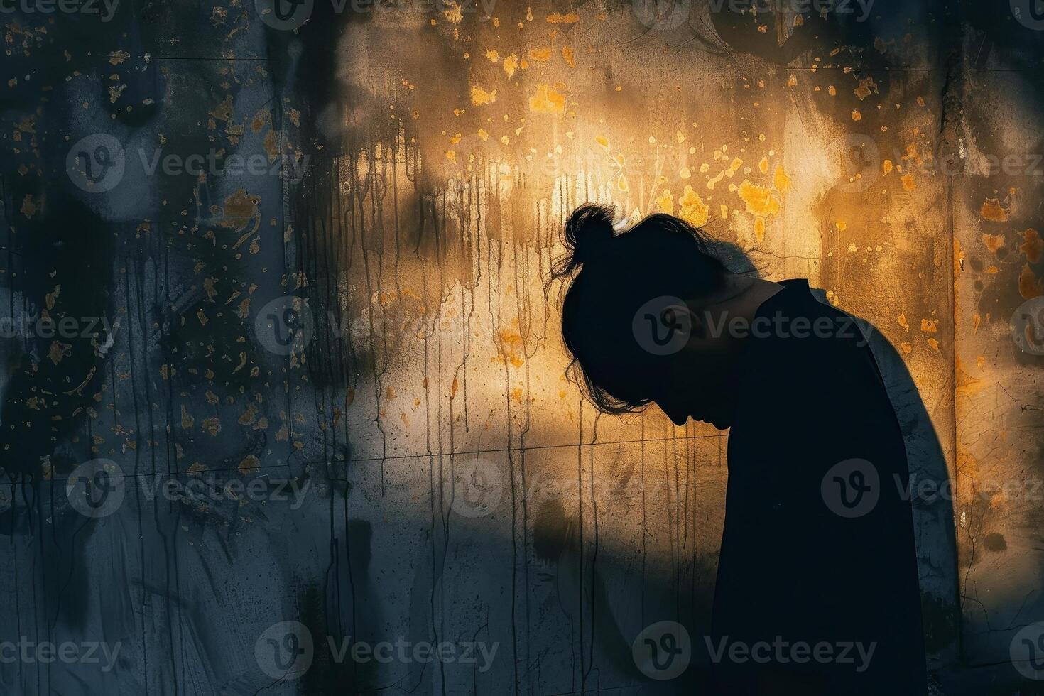 A person standing against a wall with a sun shining through it photo