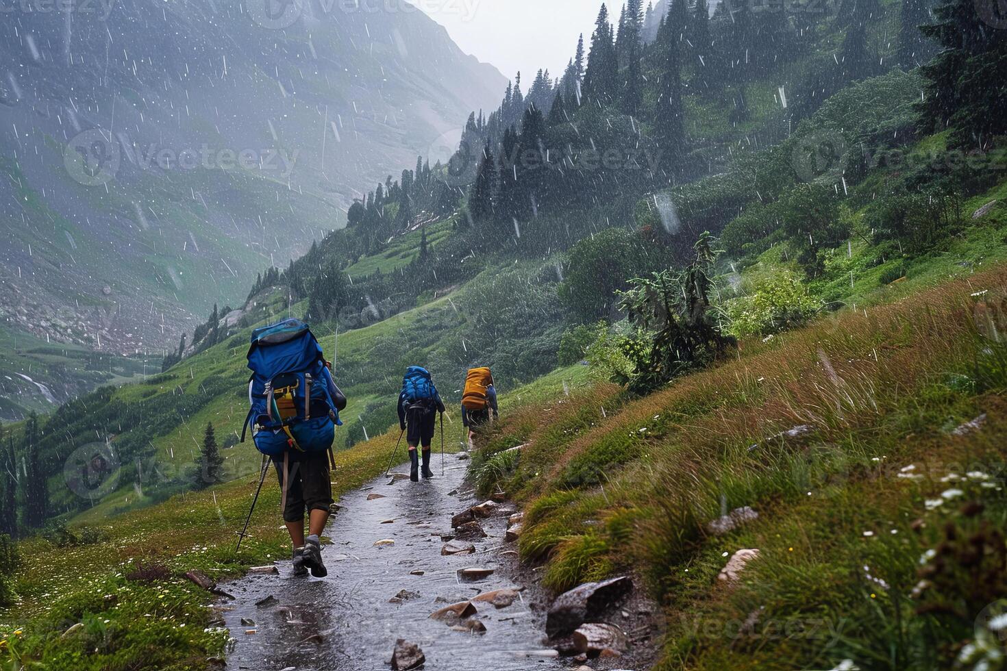 Three people with backpacks walking down a trail in the mountains photo