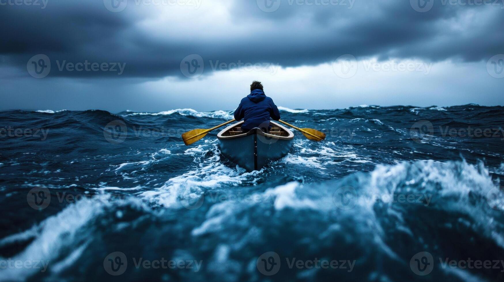 A man in a canoe paddling through rough water photo