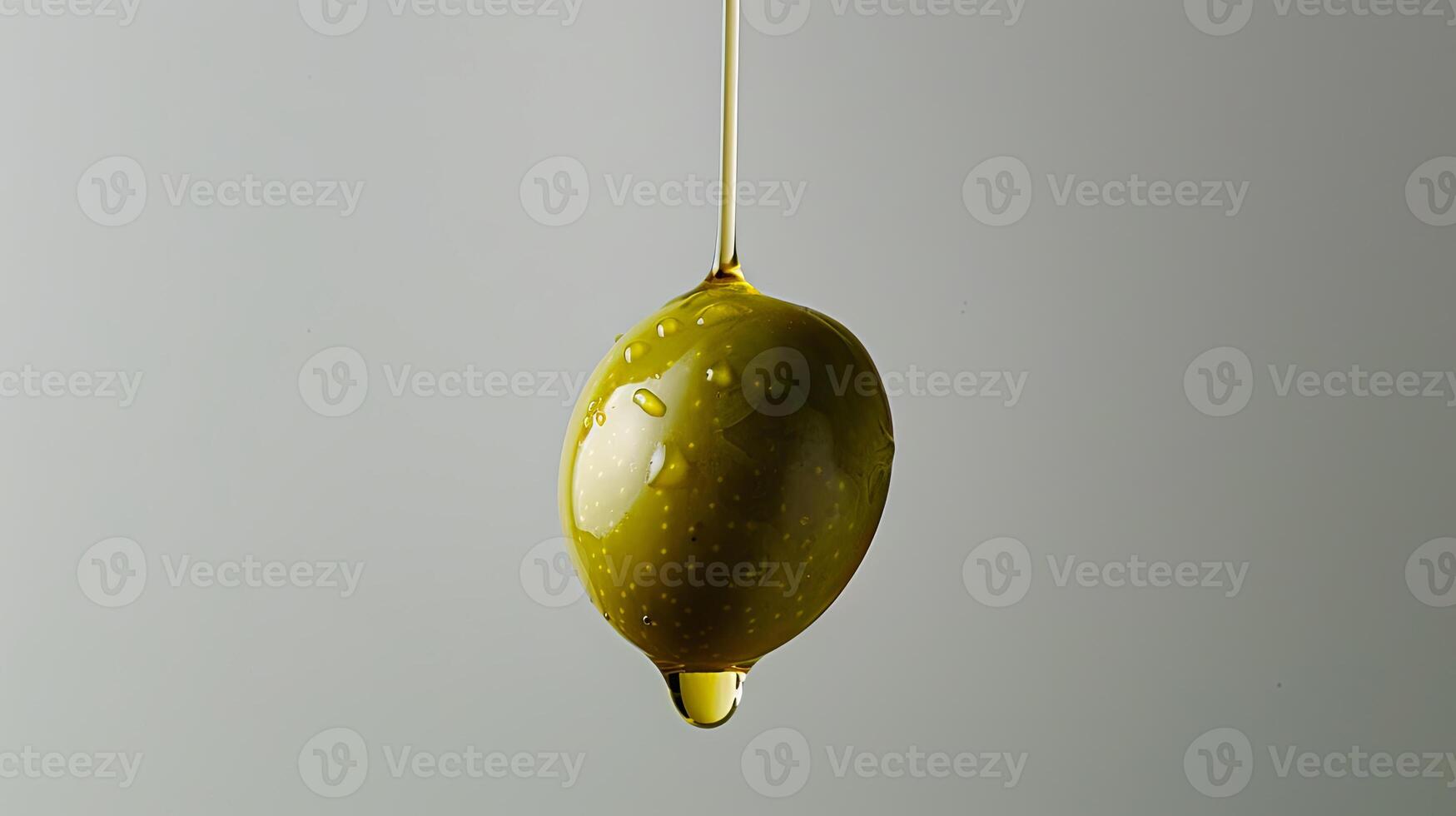 Olive oil dripping from a hanging olive photo