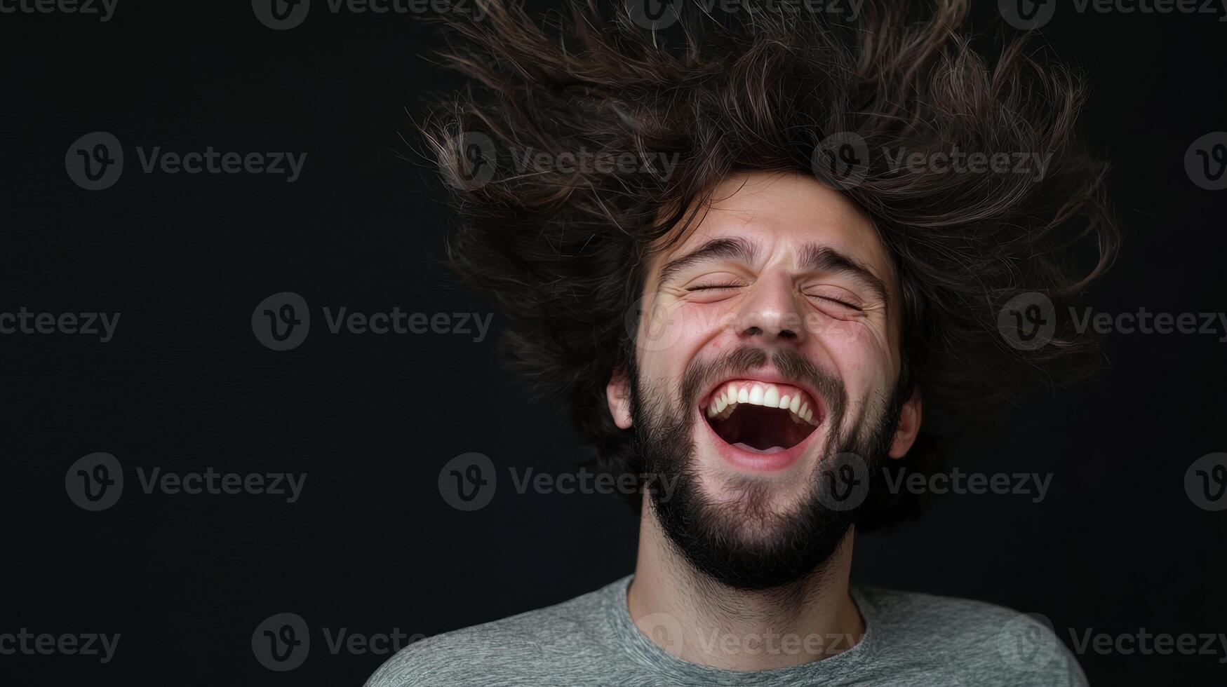 A man with long hair and a beard is laughing photo
