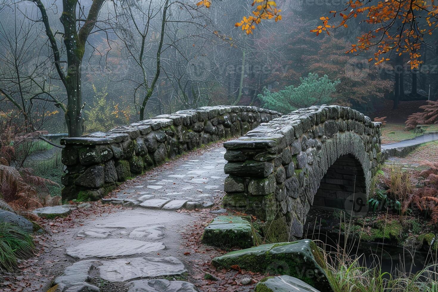 A stone bridge over a river with a path leading to it photo