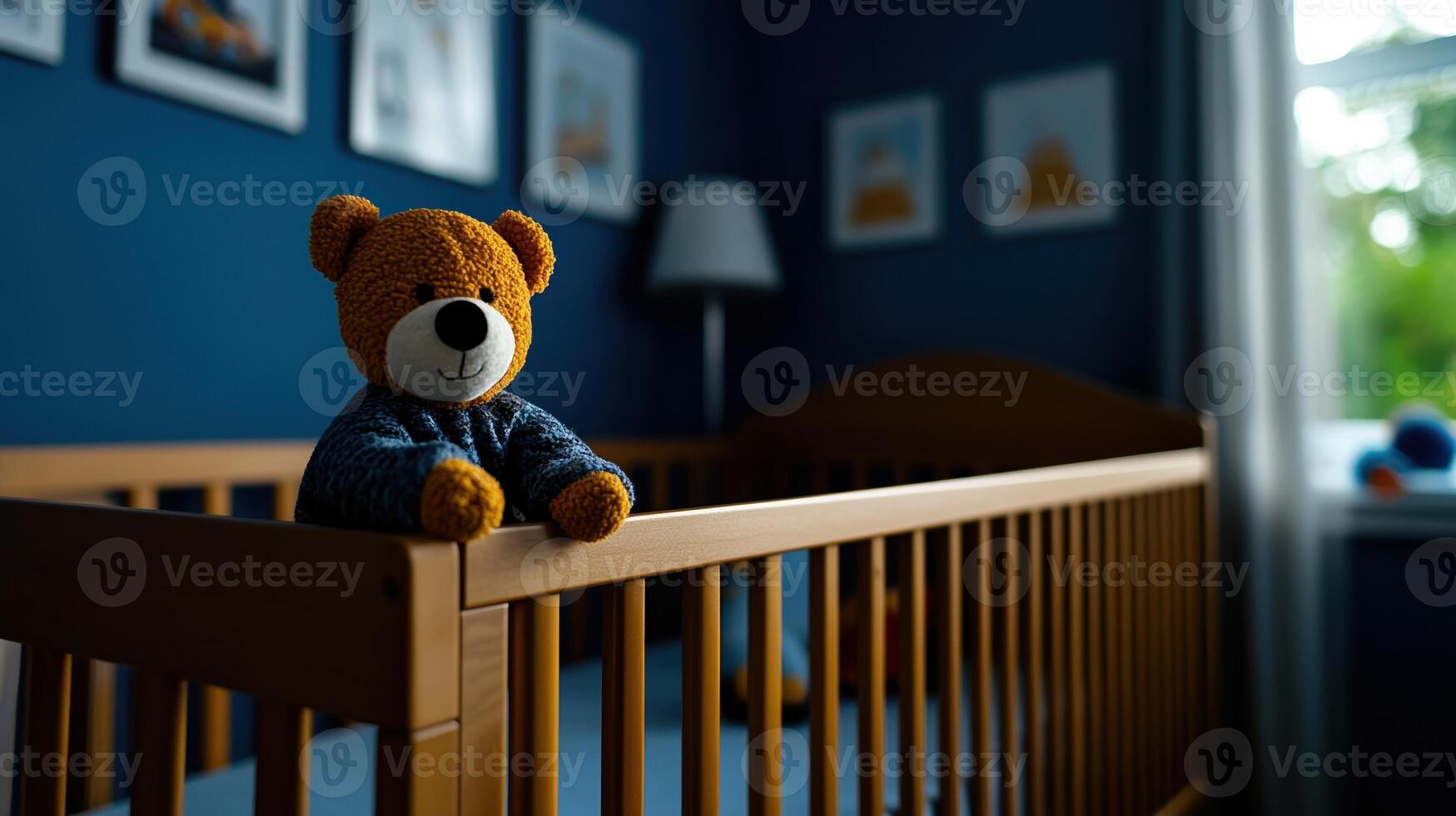 A toy bear is sitting on a crib rail photo