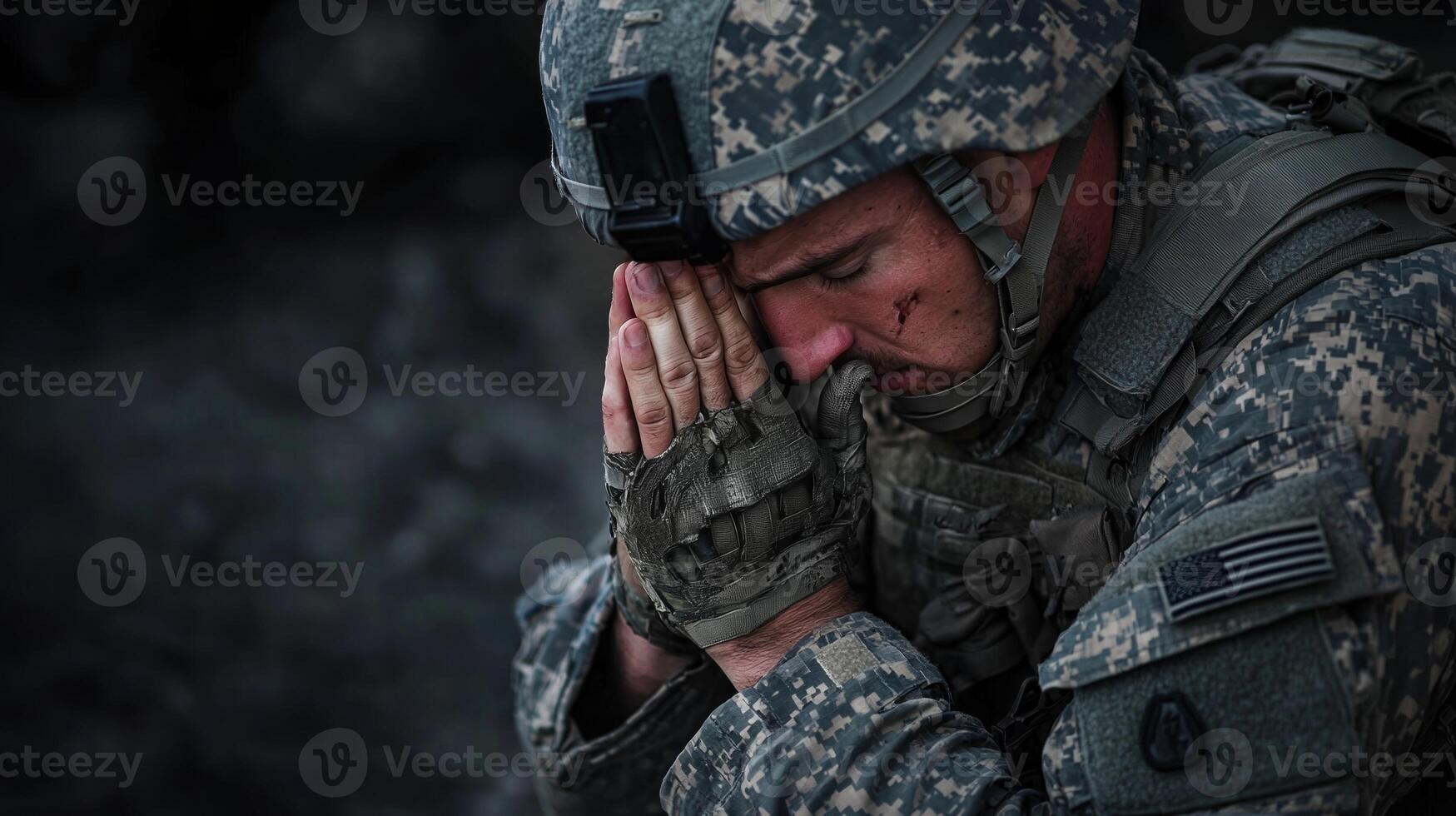 A soldier is kneeling down and praying photo