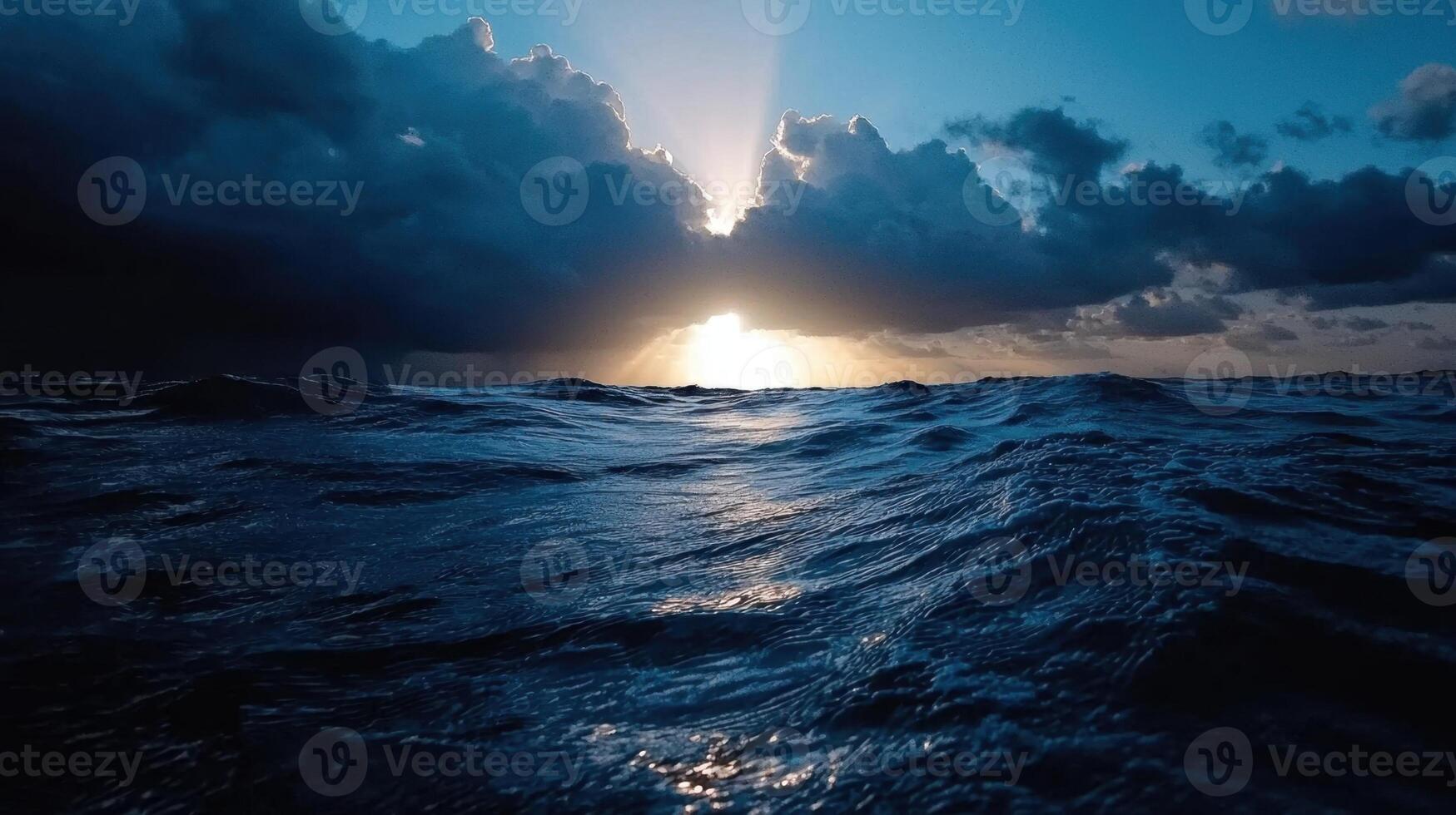 The sun shines through the clouds over the ocean photo