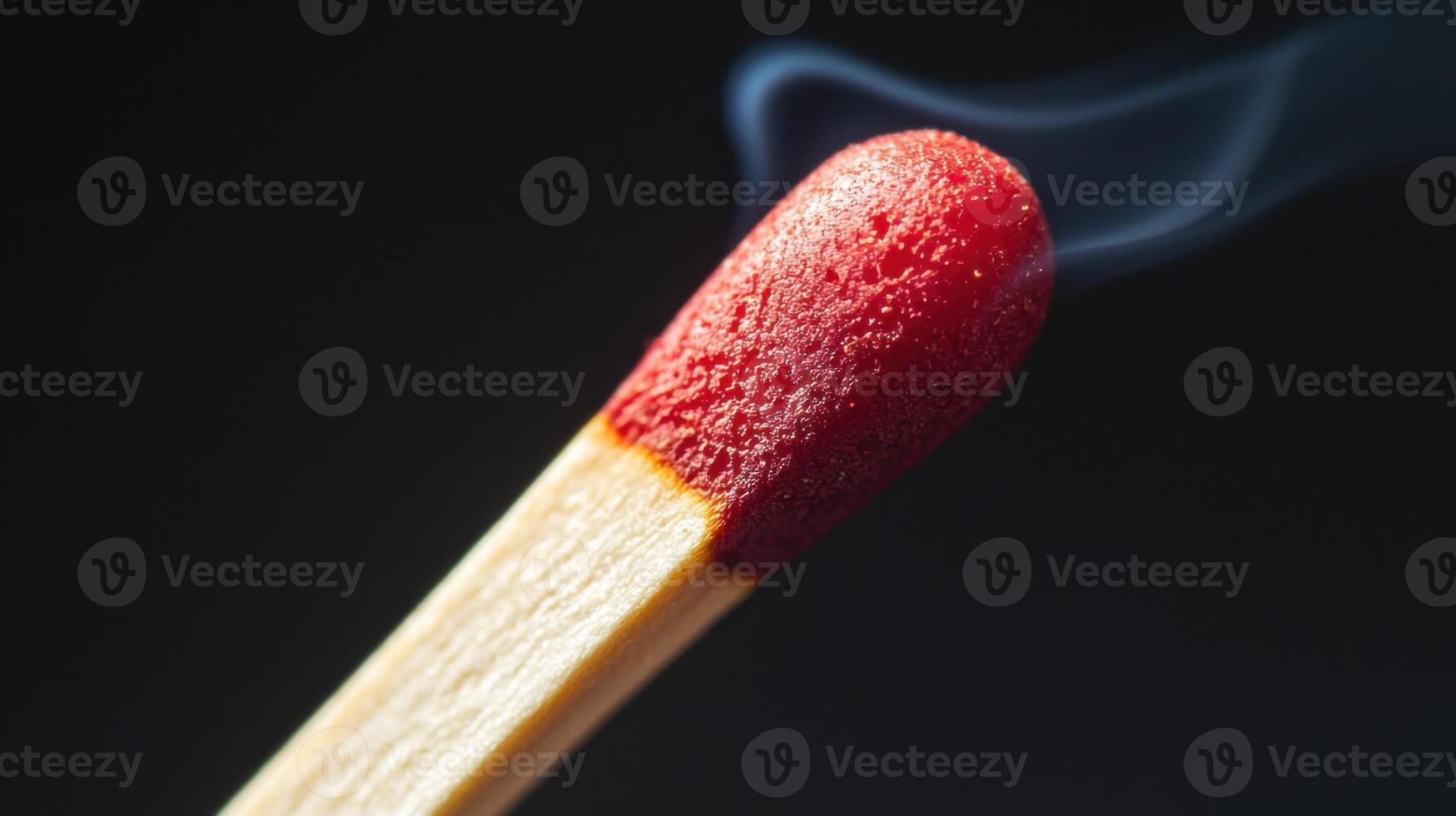 A matchstick with a red tip is lit photo