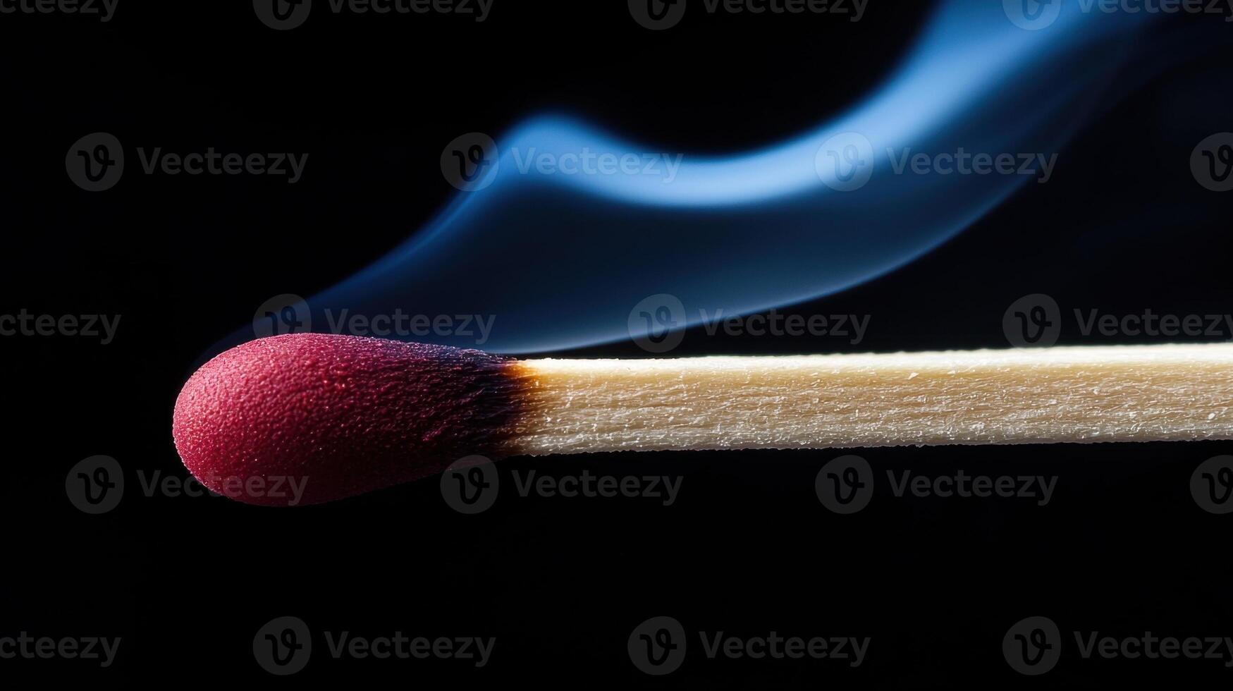 A matchstick with a red tip is lit photo