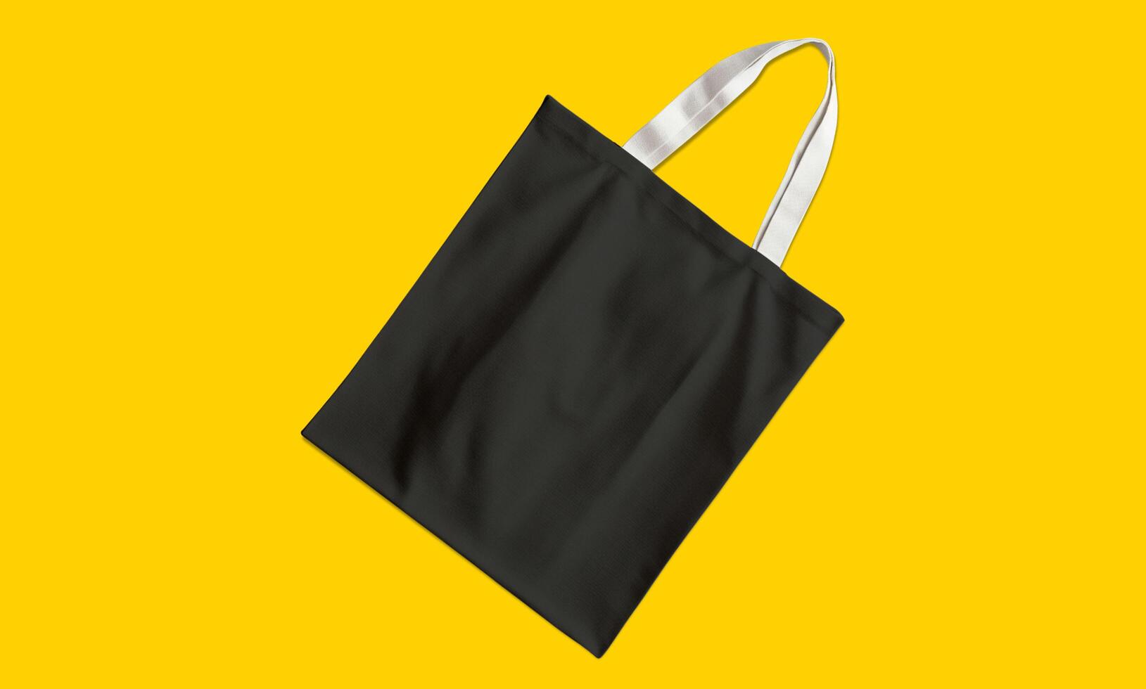 A black tote bag on a yellow background photo
