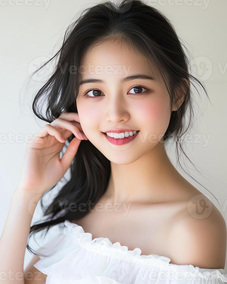 Beautiful young Asian woman with long black hair, smiling gently. Headshot portrait. photo