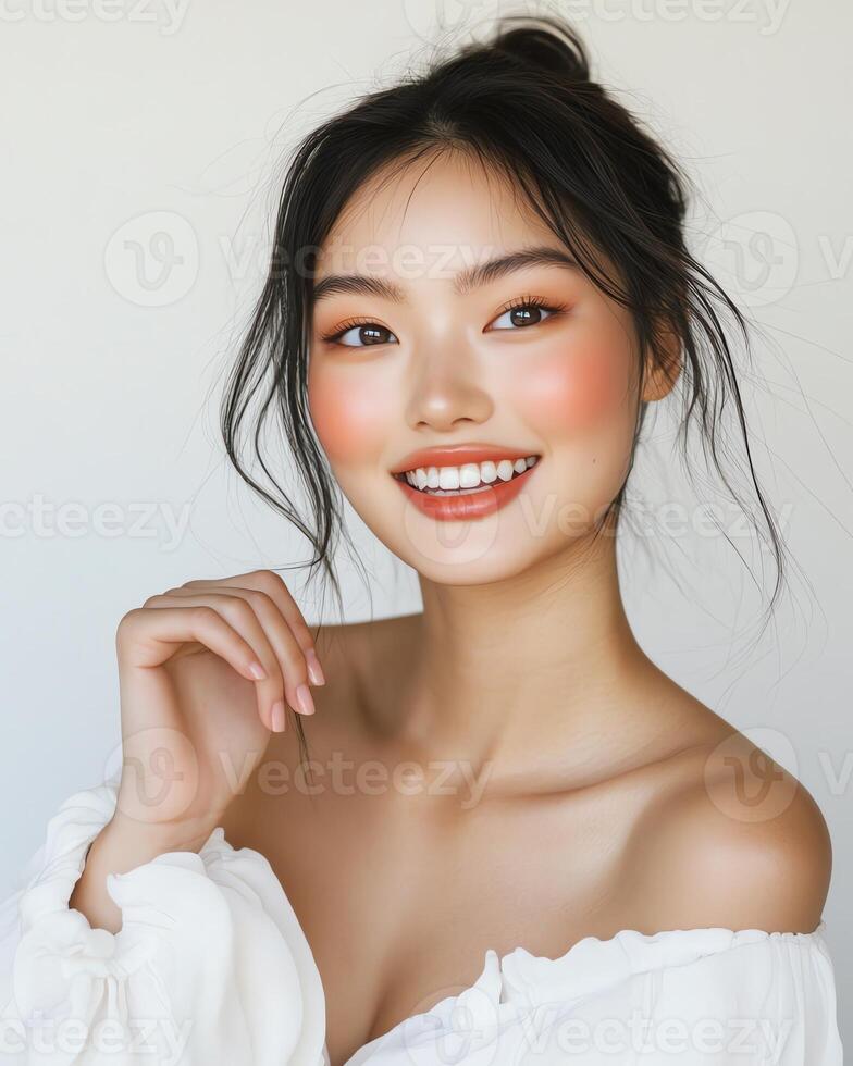 Beautiful Asian woman with peach makeup, smiling, off-shoulder blouse. Radiant skin, healthy glow. photo